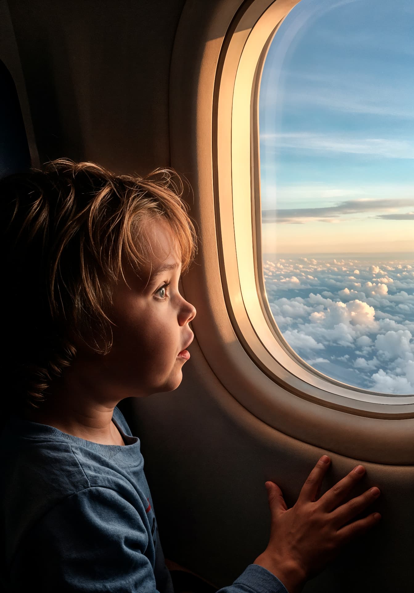 Criança olhando pela janela do avião